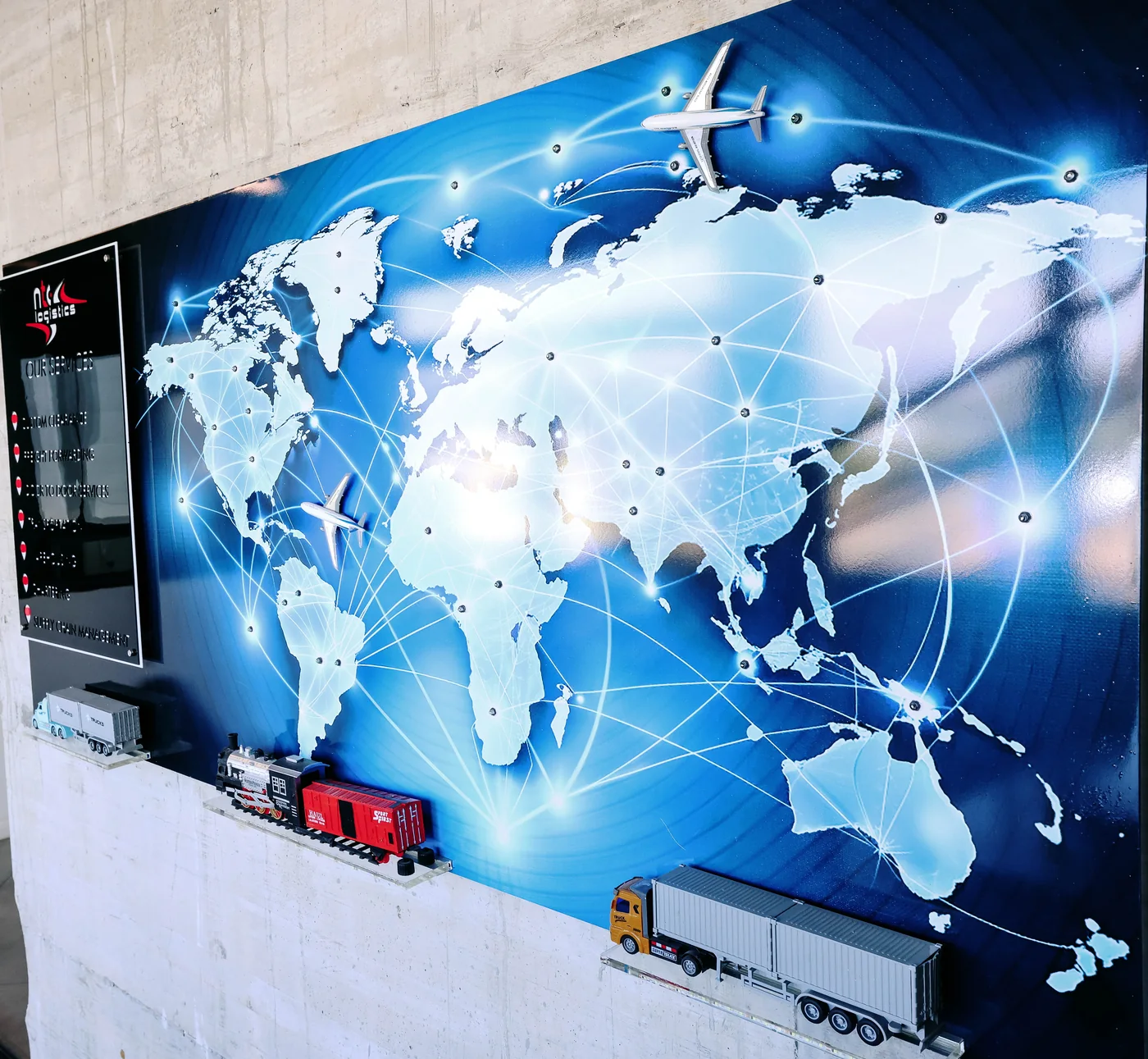 World map with transport routes and model aircraft, train and trucks