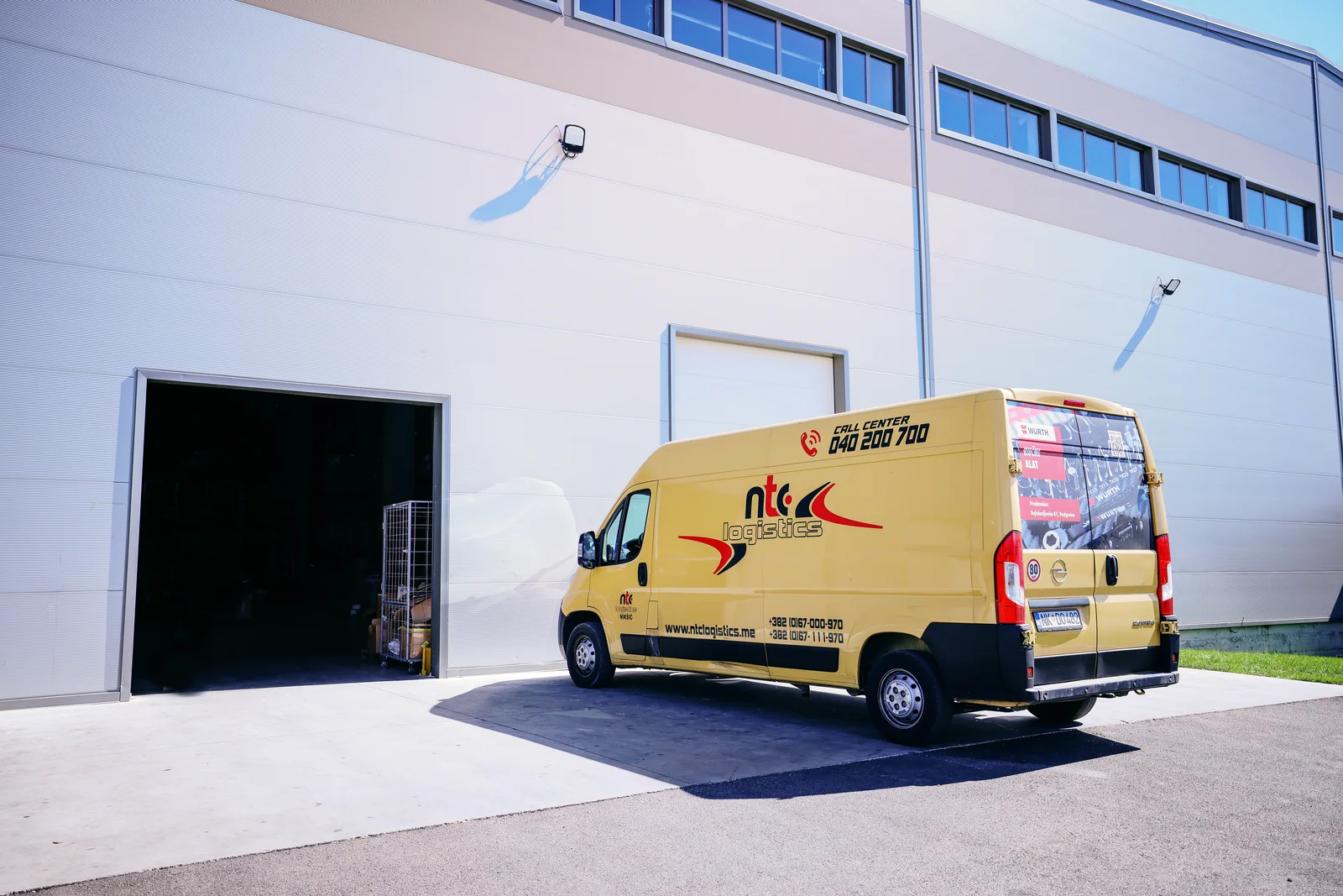 Yellow NTC Logistics delivery van outside the warehouse entrance