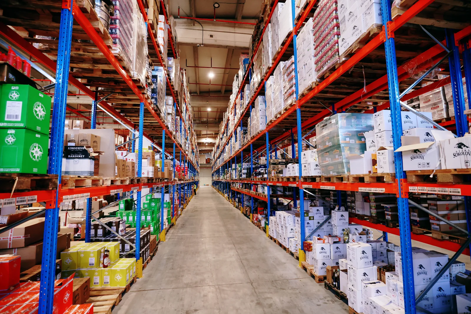 Warehouse aisle between pallet racks stocked with goods