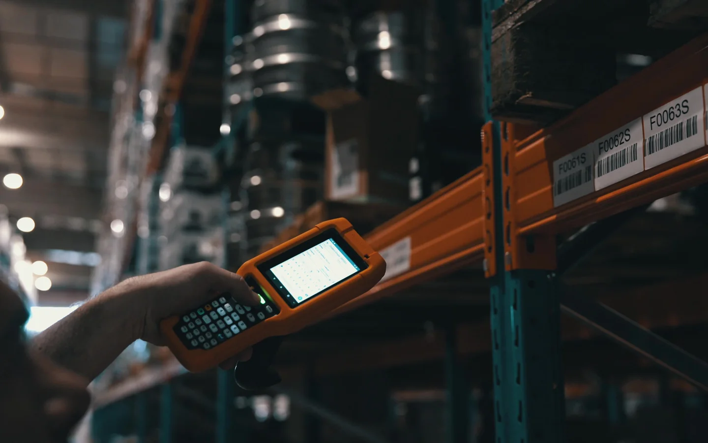 Handheld terminal in use beside labelled rack locations